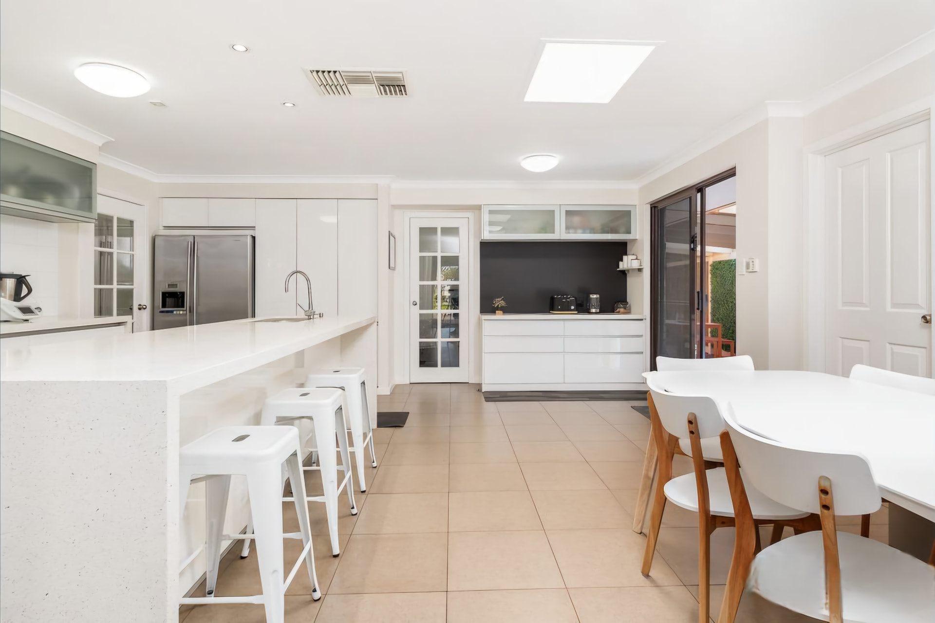 Leeming open plan white kitchen with breakfast bar and stools